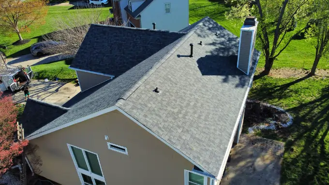 Matthews homeowners smiling in front of their newly replaced roof by Triumph Roofing